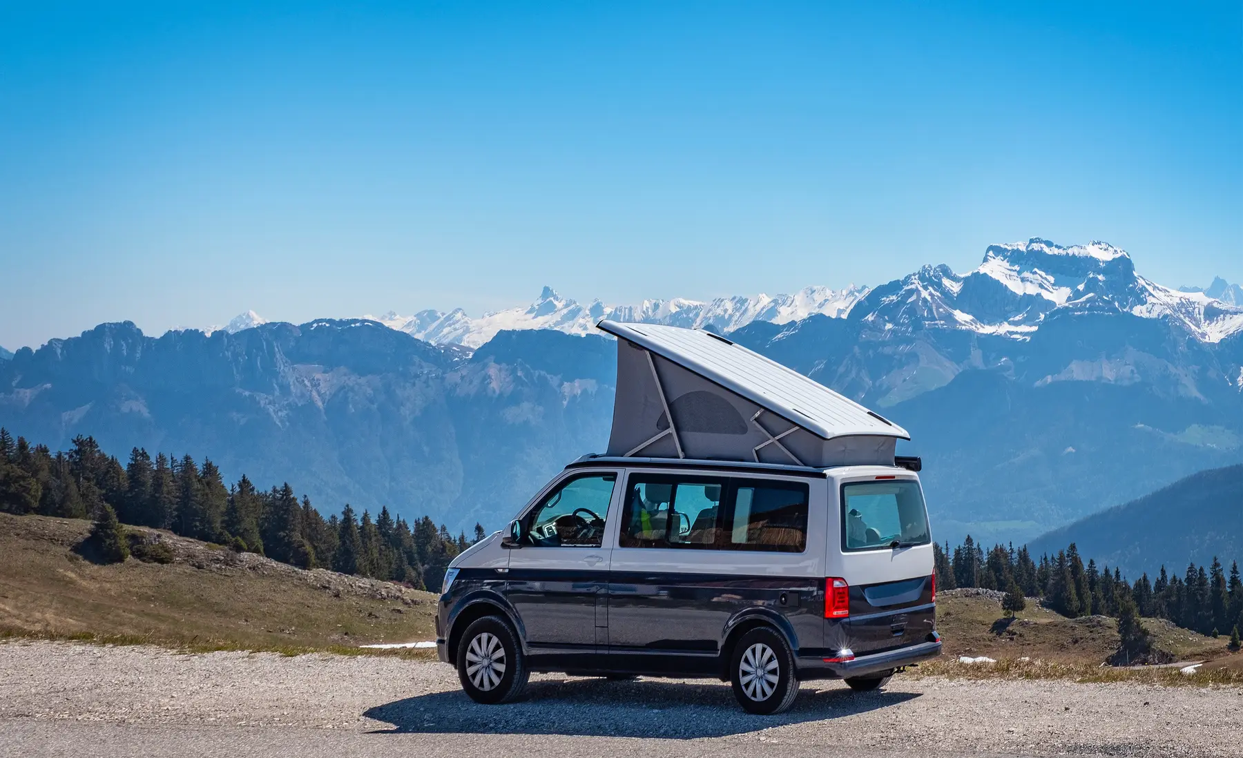Camper beWinkle junto a un embalse con rayos de sol al atardecer en plena travesía