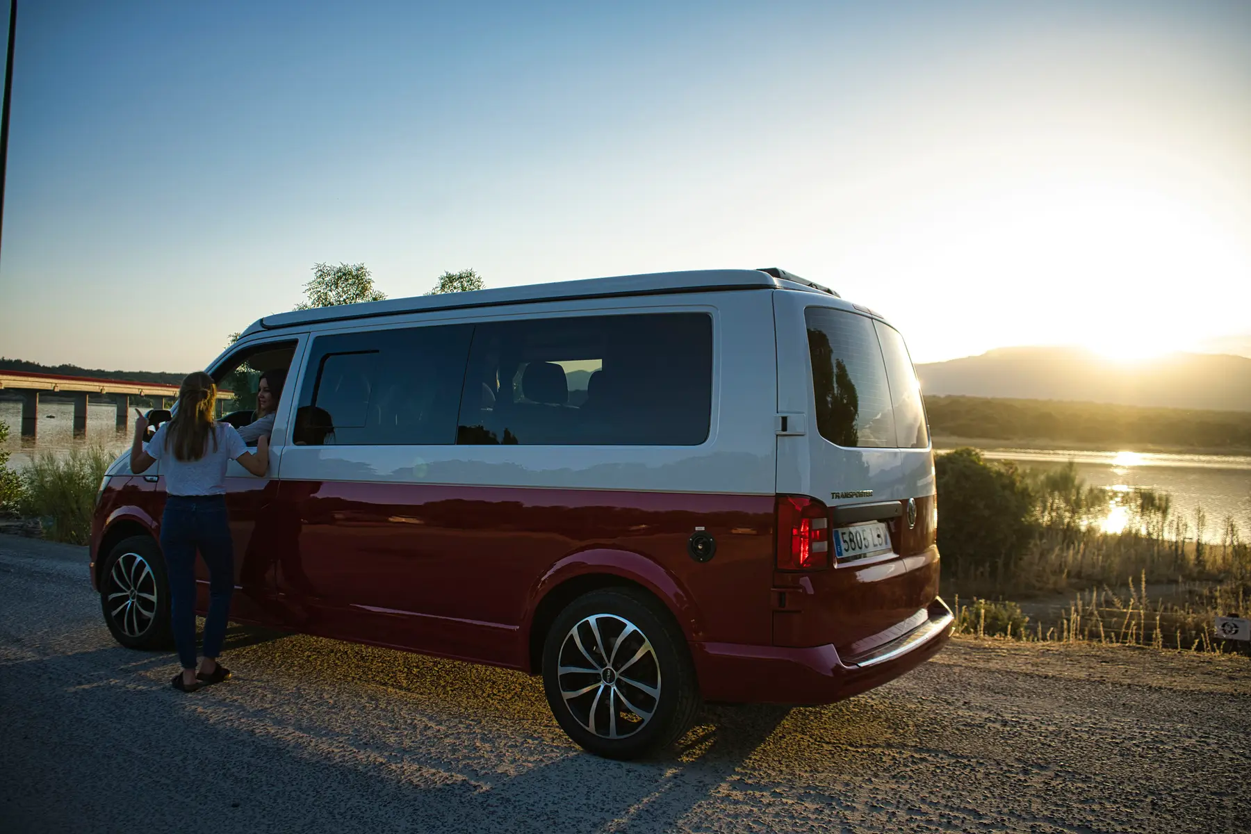 Camper beWinkle de perfil junto a un río al atardecer, lista para una ruta por España