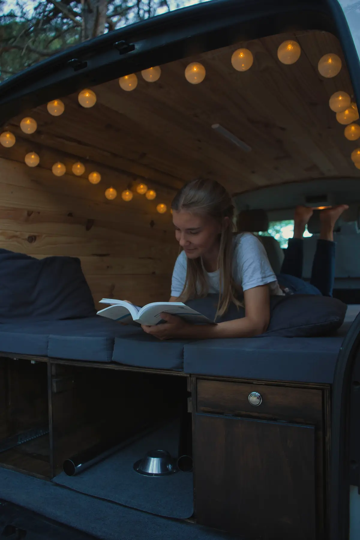 Interior de una camper beWinkle de noche con guirnaldas de luz cálida