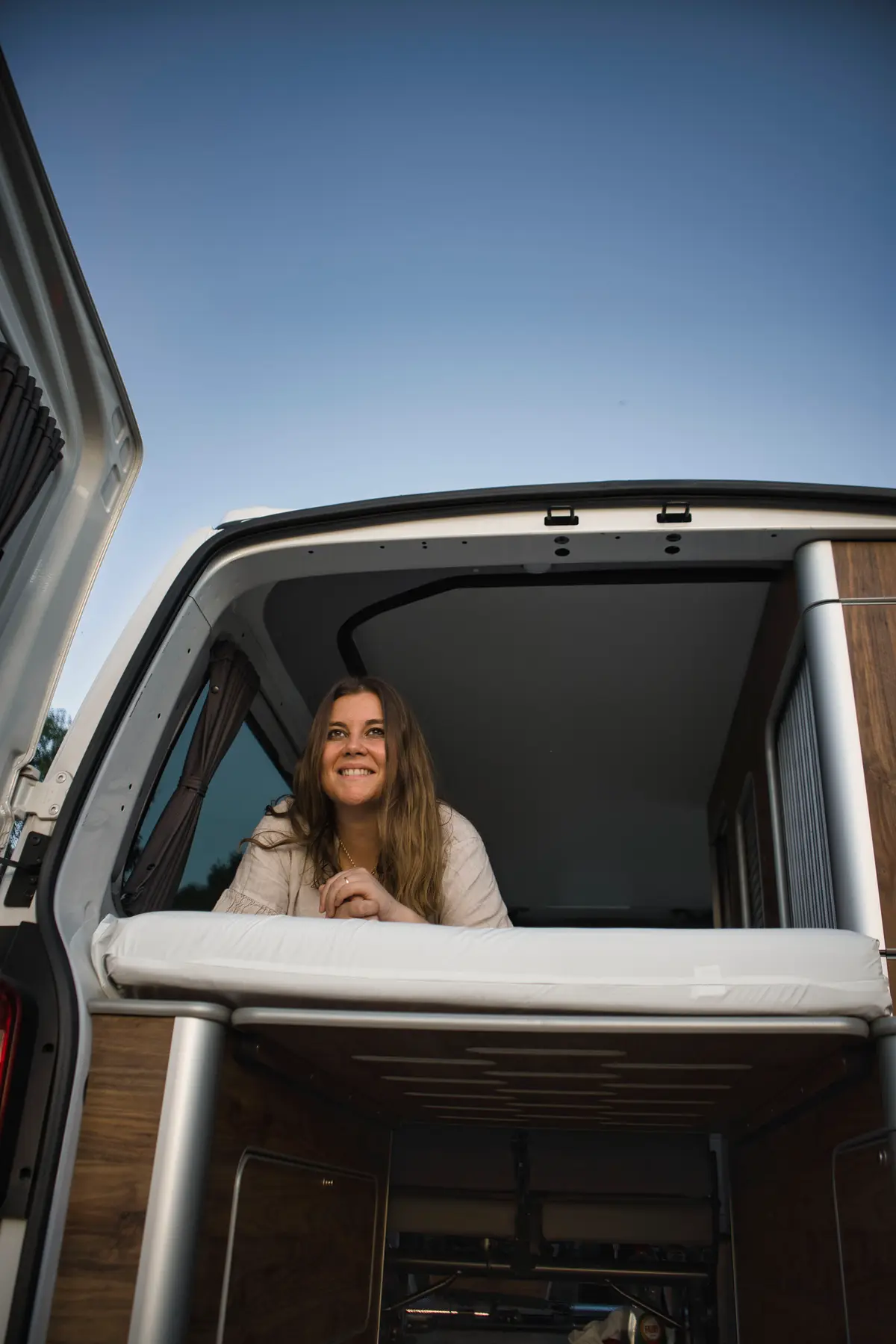 Viajera asomada al techo elevable de una camper beWinkle