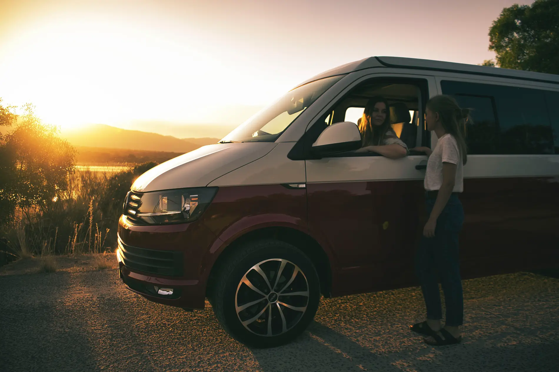 Viajeros junto a una camper beWinkle a la orilla de un lago