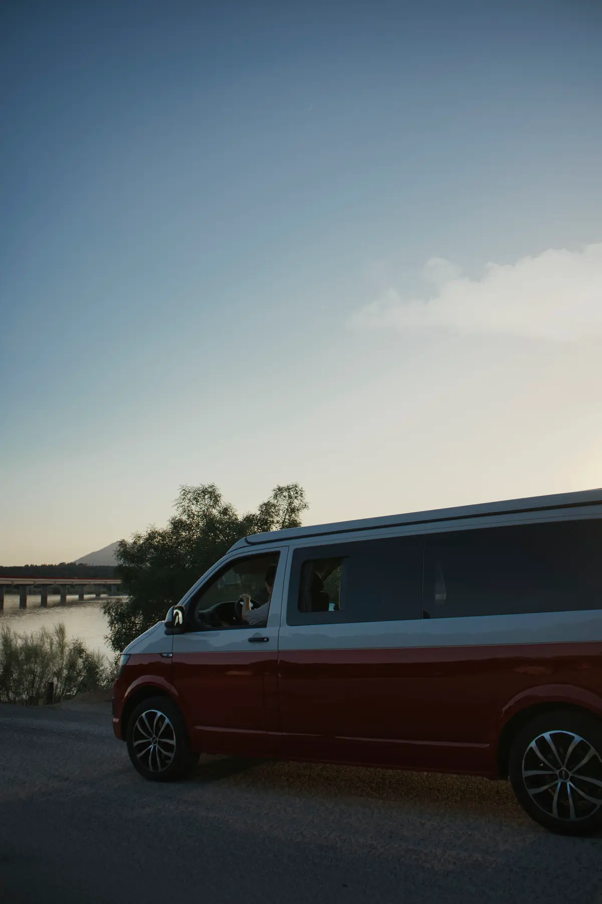 Camper beWinkle roja por una carretera abierta al atardecer